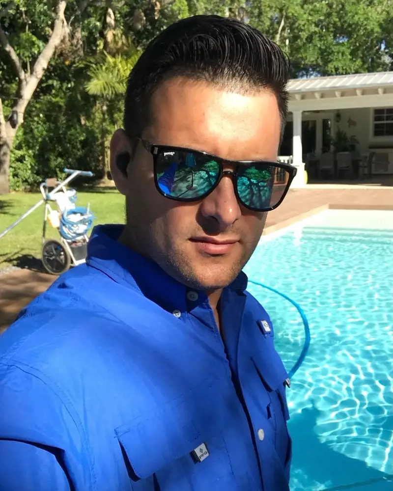 Owner of American Blue Pools next to a client's pool